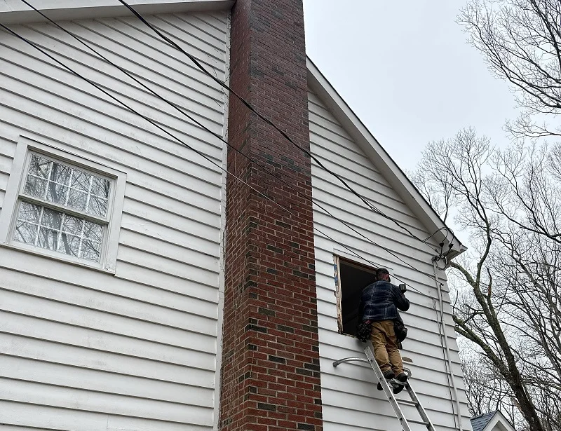 Window Solutions Plus master installer on a ladder removing a window in WIlton,CT